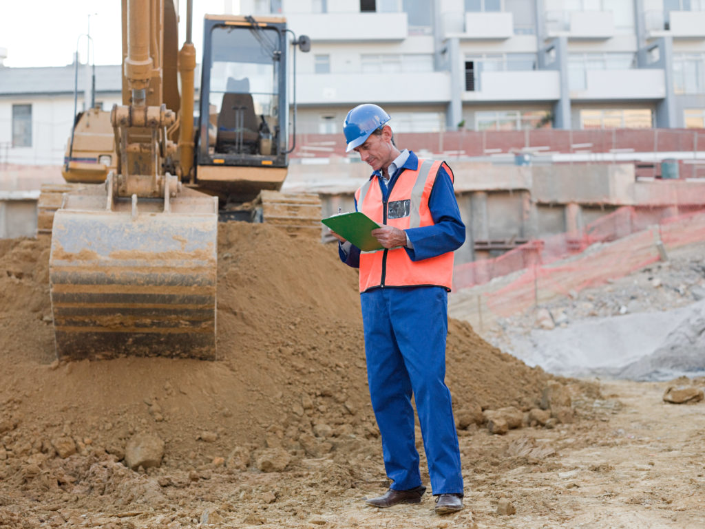 trabalhador anotando práticas de saúde e segurança no trabalho na construção civil