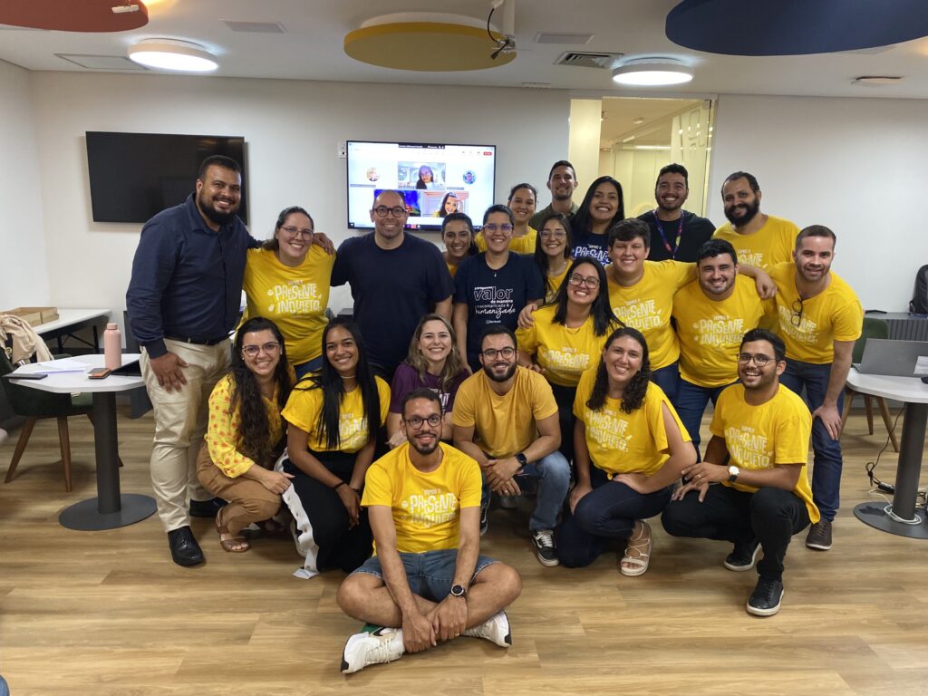 integrantes da equipe do BPO para um hackaton. todos vestem amarelos e pousam na sala de experiência em nossa unidade recife