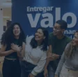 6 funcionários da bernhoeft rindo entre si, atrás deles uma parede azul com o propósito da empresa ''entregar valor de maneira descomplicada e humanizada''